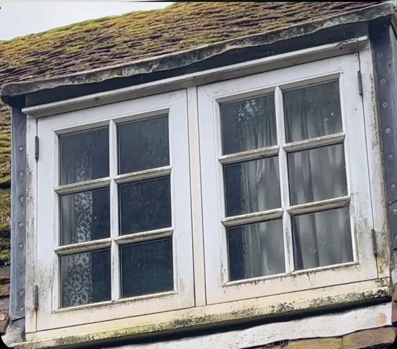 Cottage casement windows with grimy frames and dirty glass before cleaning
