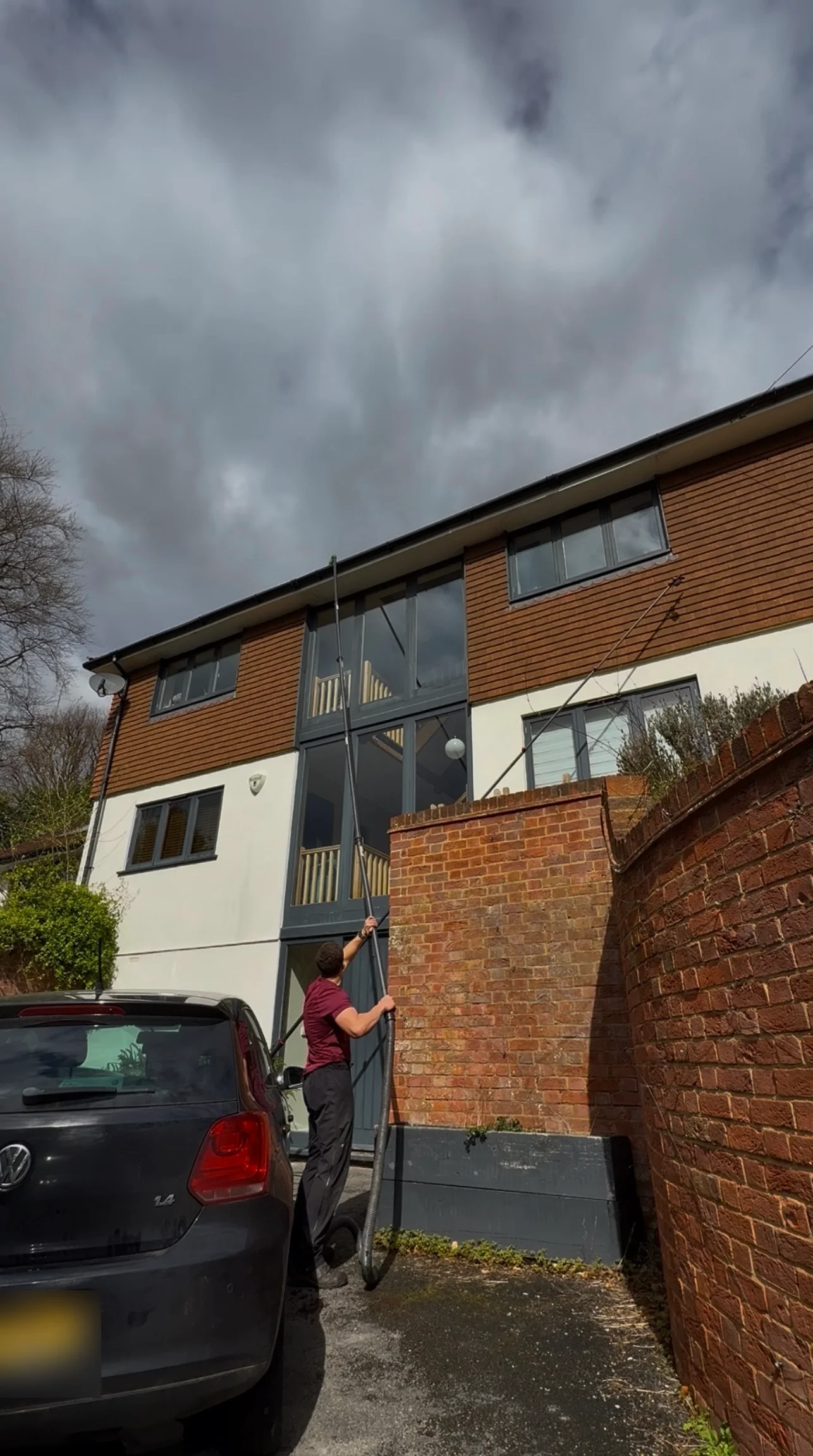 GWC operative clearing the gutters of a three-storey house from the ground using a high-reach vacuum pole